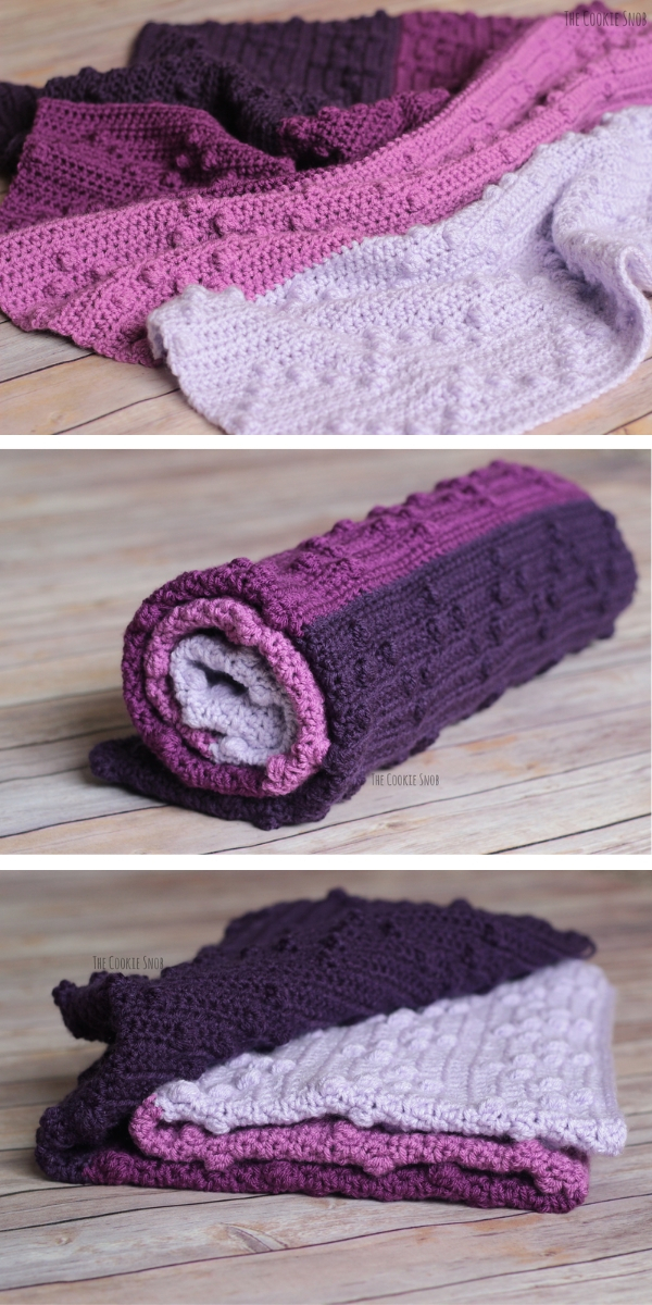 bobble-wobble blanket in violet shades laying on a wooden floor