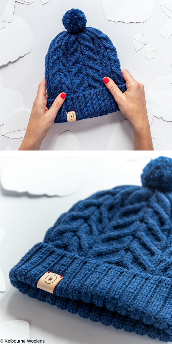 Dark blue beanie with pompon on white background