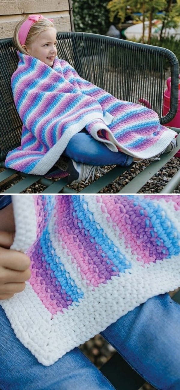 a girl sitting in the home garden wrapped in a plush striped blanket in unicorn colors