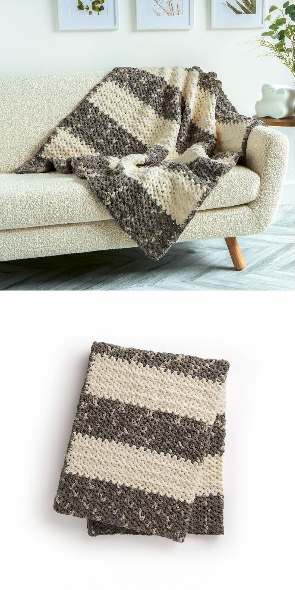 a V-Stitch striped blanket in white and grey colors presented on the modern white couch