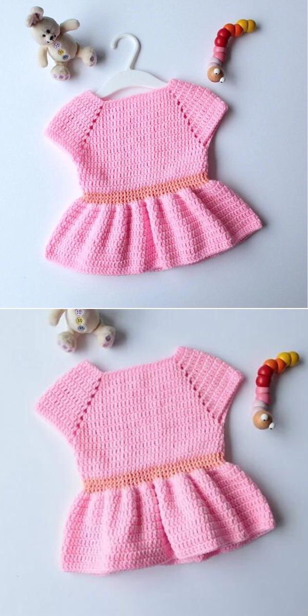 crocheted baby dress in pink color laid next to children's toys