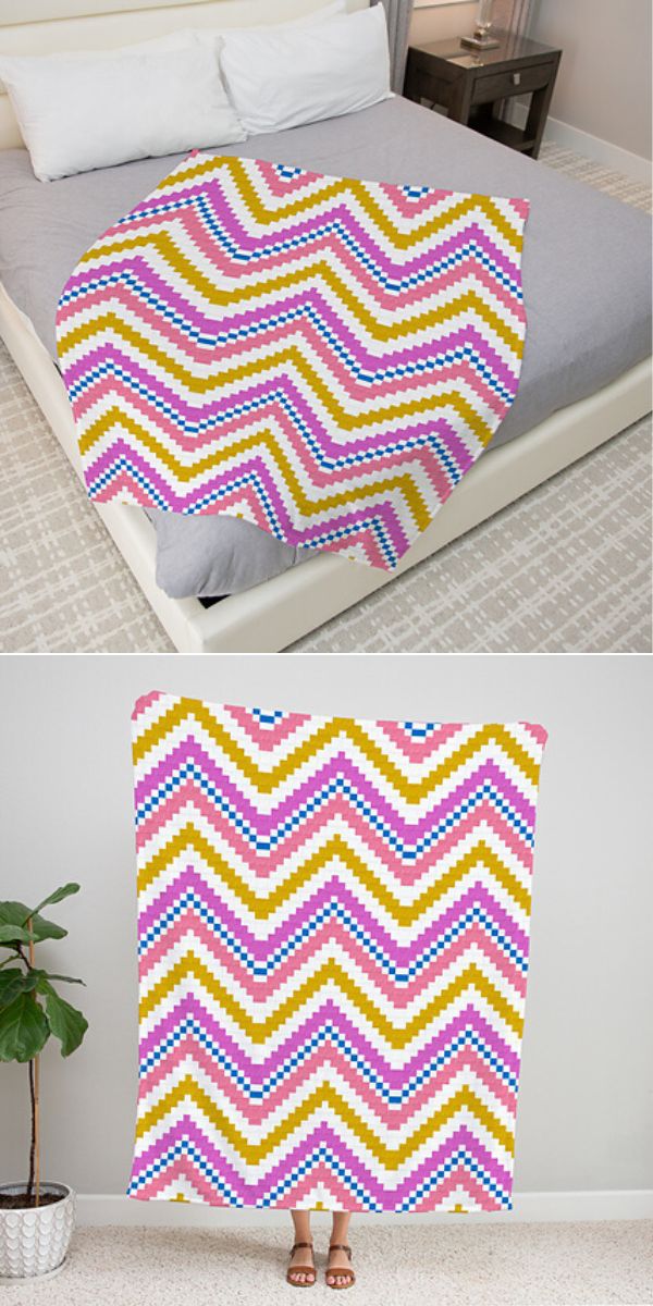 a crochet bright colorful blanket with a chevron design laid on a bed and held by a person
