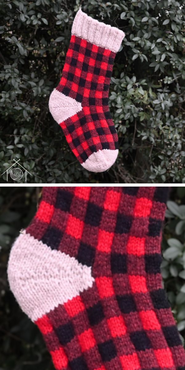 A knitted red and black plaid stocking hanging on a tree.