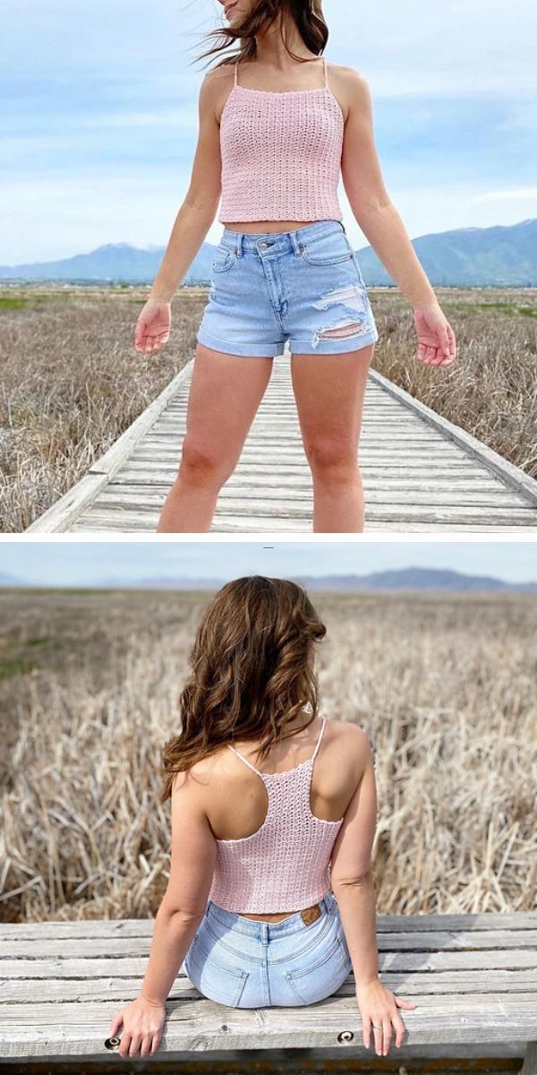 Woman in pink halter top and denim shorts on wooden boardwalk with scenic nature background.