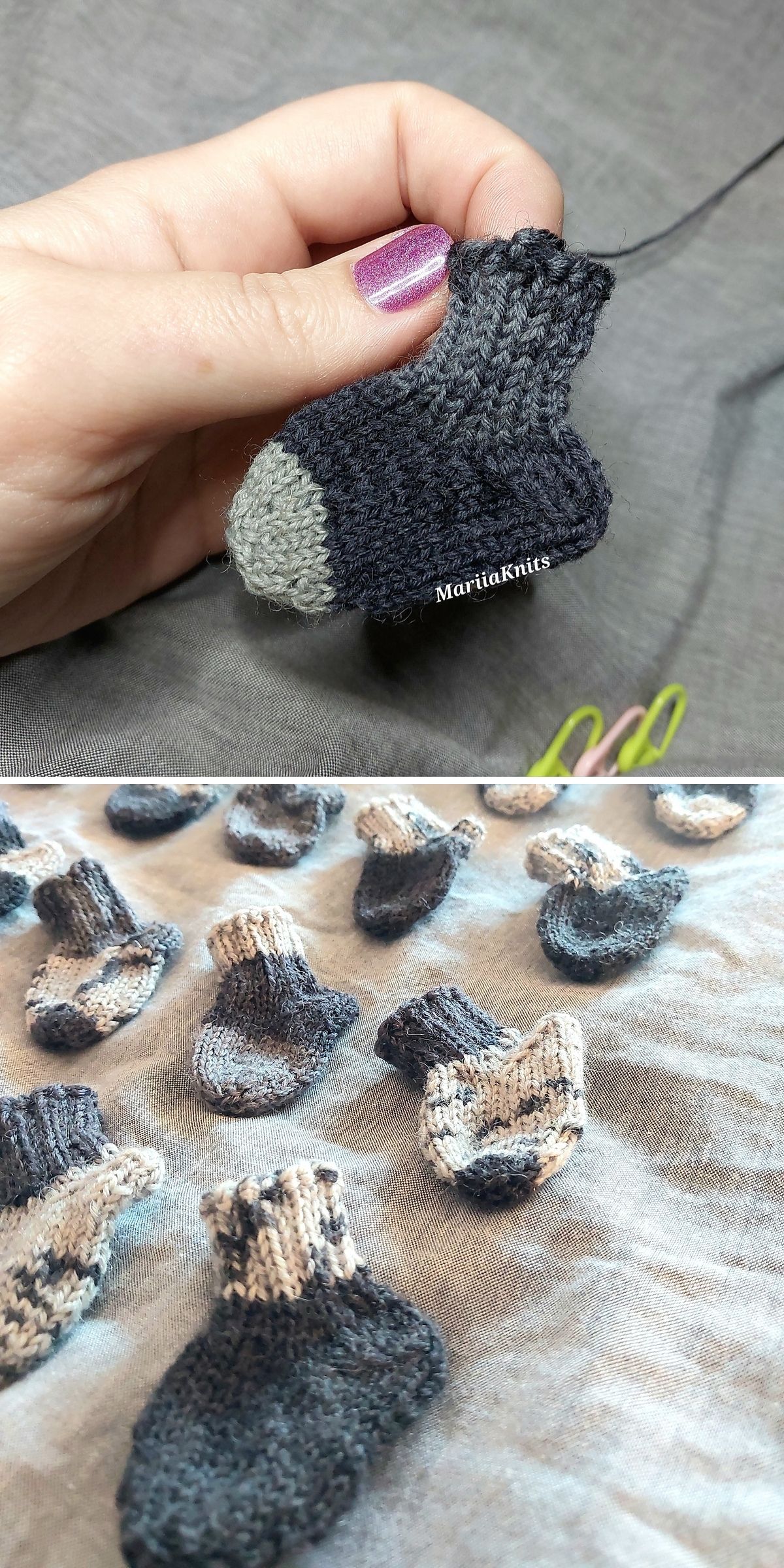 A hand holds a miniature knitted baby sock, with several more scattered on a grey surface below.