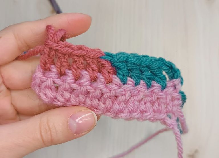 a piece of crocheted fabric in a hand showcasing how to change colors in crochet