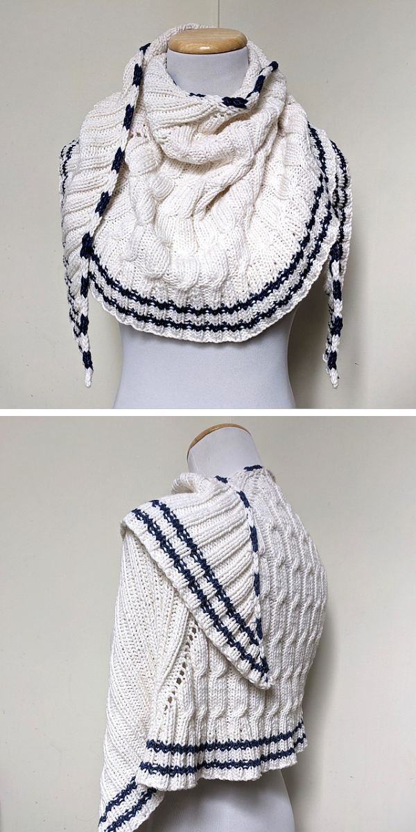 A knitted white shawl with blue stripes along the edges, featuring a textured pattern and draped around the shoulders.