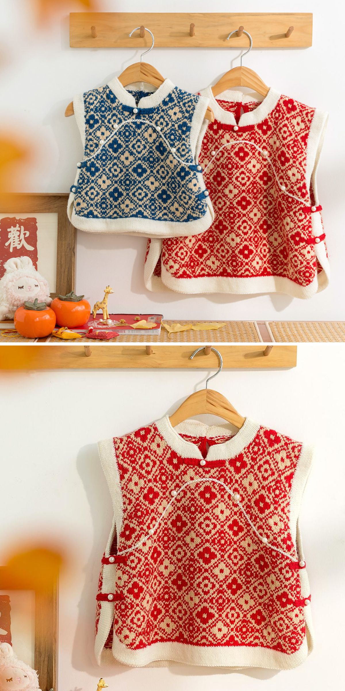 Two knit vests with a geometric pattern hang side by side; one in blue and white, the other in red and white, on wooden hangers against a pristine white wall adorned with decorative items nearby.