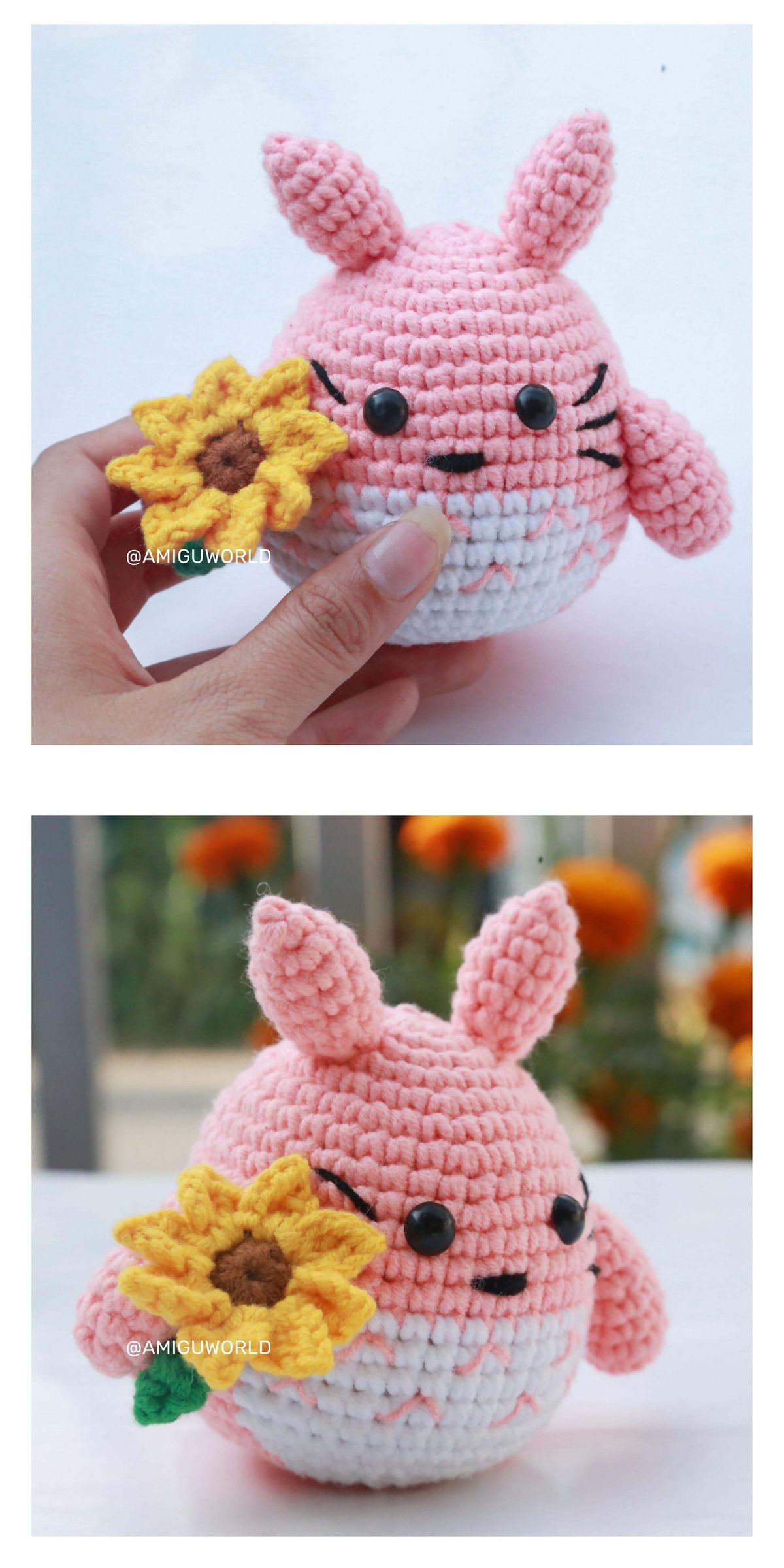 A hand holding a pink crochet Totoro creature with bunny ears and a yellow crocheted sunflower, shown from the front and slightly angled side.
