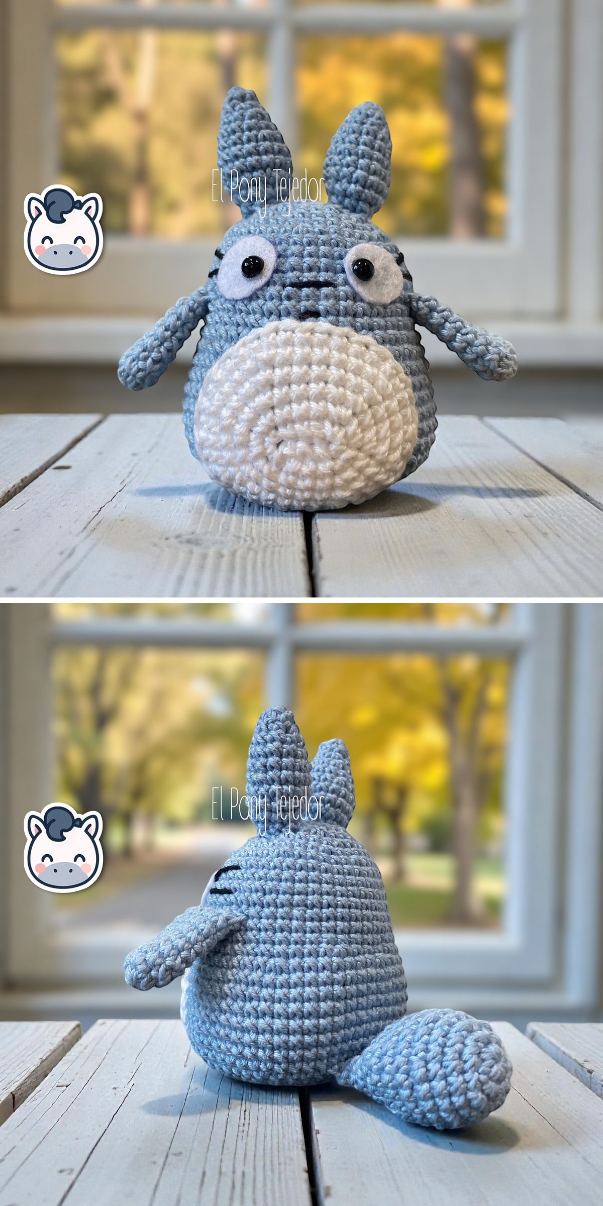 A crochet Totoro plush toy in blue and white is shown from the front and back, placed on a white wooden surface with a blurred window and yellow foliage in the background.