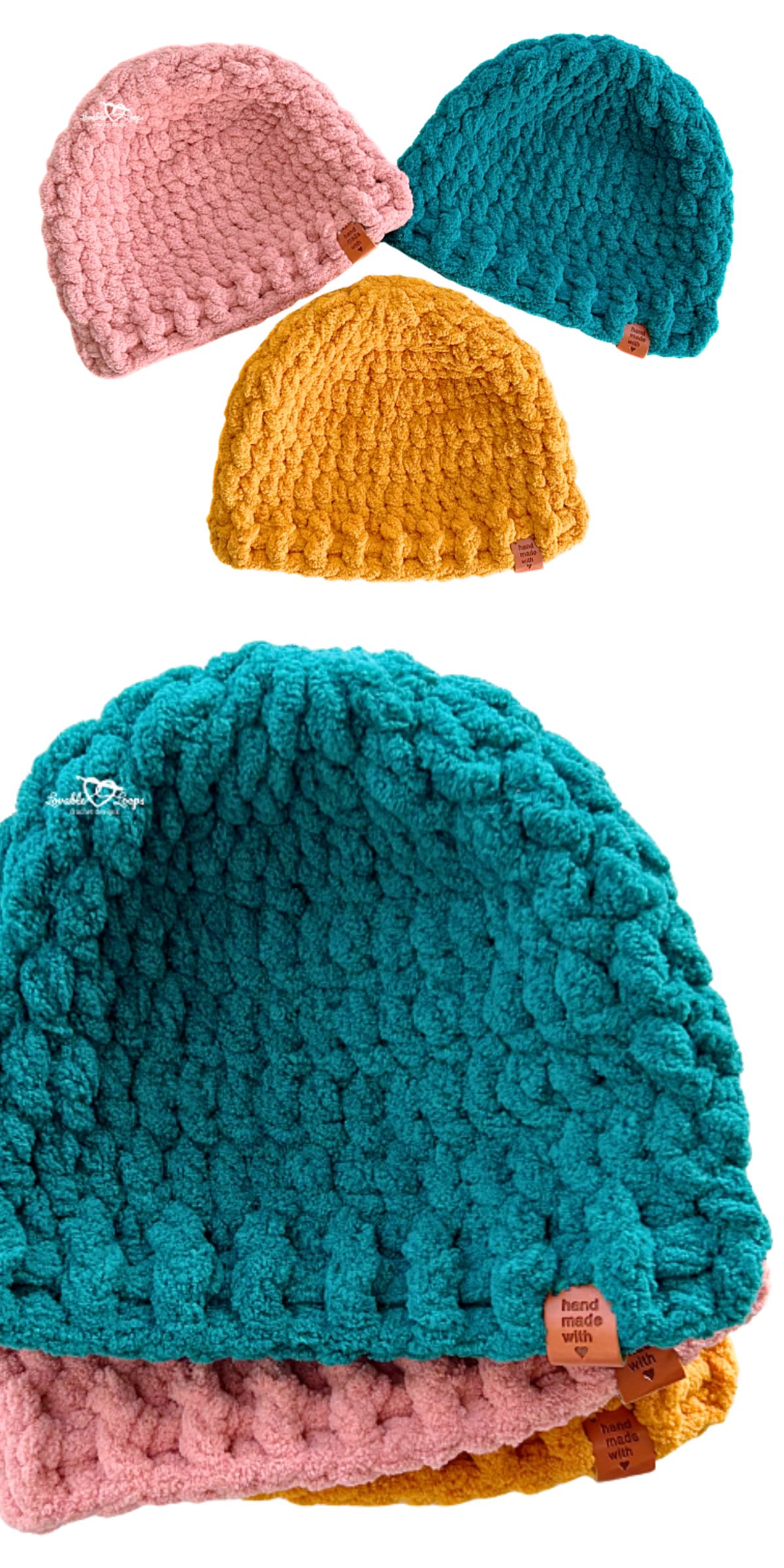 Three chunky crochet beanies in pink, teal, and mustard yellow are stacked together, each featuring a small brown "hand knit" tag.