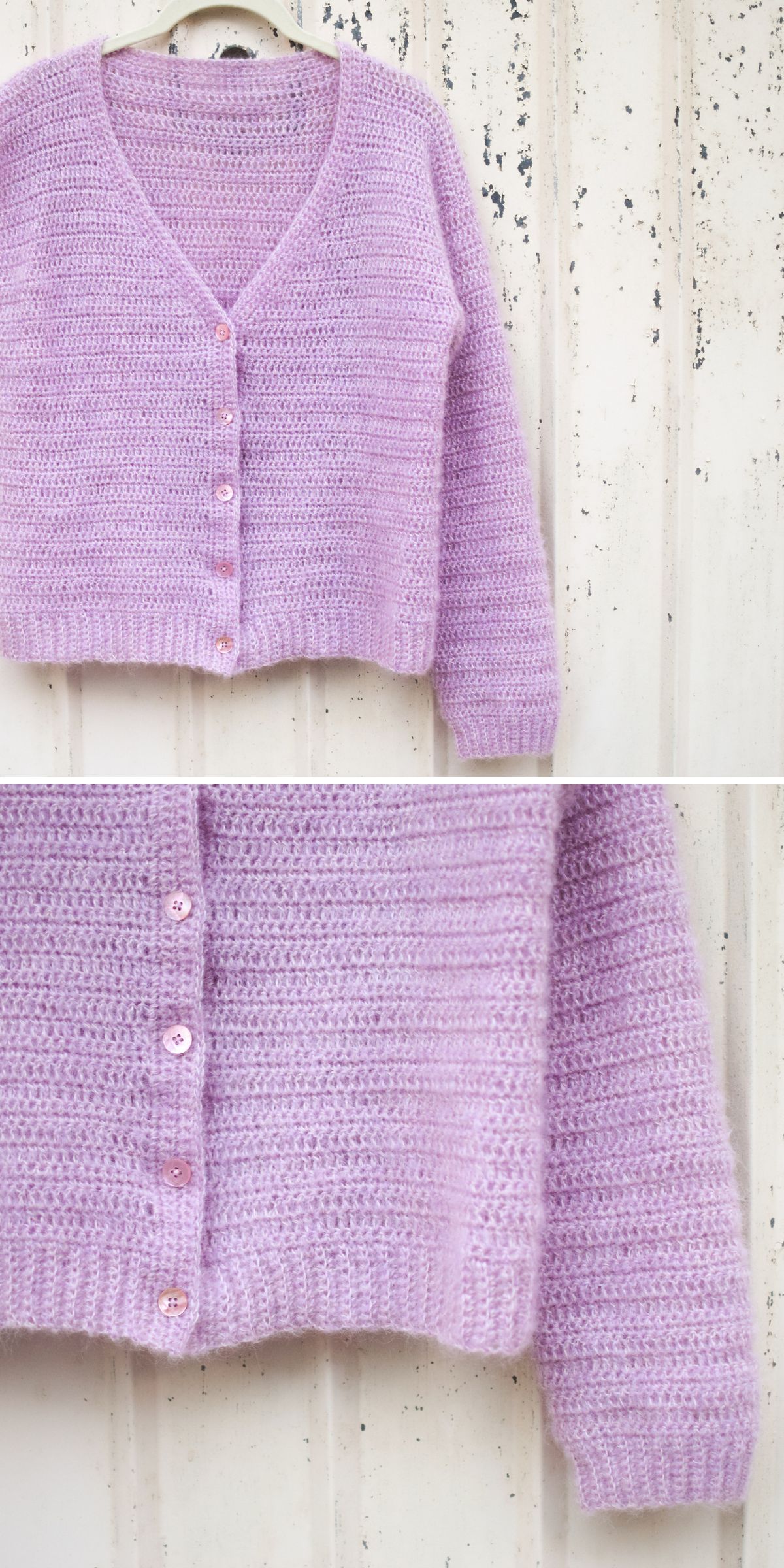 A lavender crochet cardigan with a V-neck, three buttons, and ribbed cuffs and hem hangs on a hanger against a white textured wall.