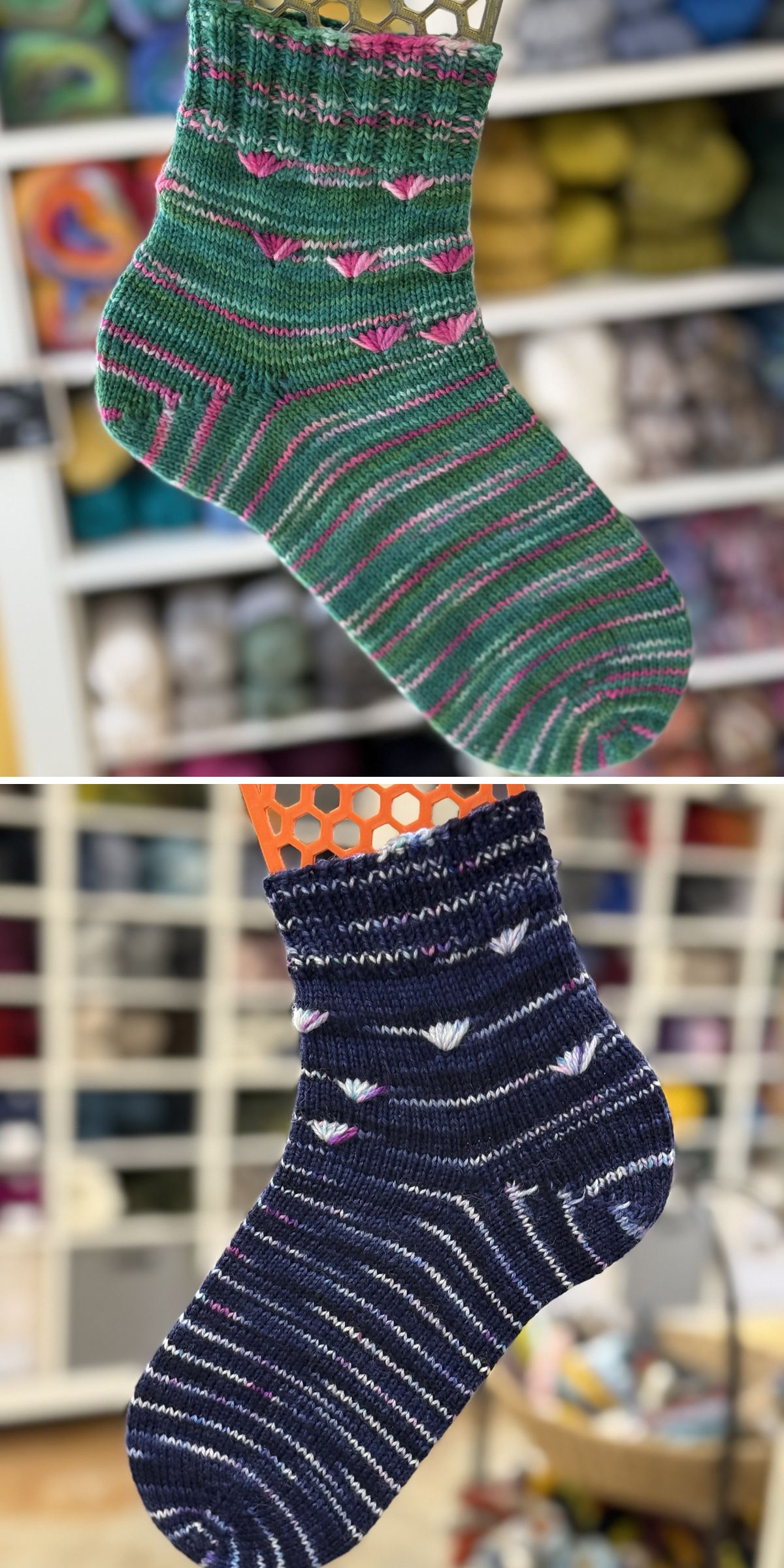 Two hand-knitted socks, crafted with unique knitting patterns for socks, are displayed separately: one is green with pink and purple stripes, the other navy with white and lilac stripes. Yarn is visible in the background.