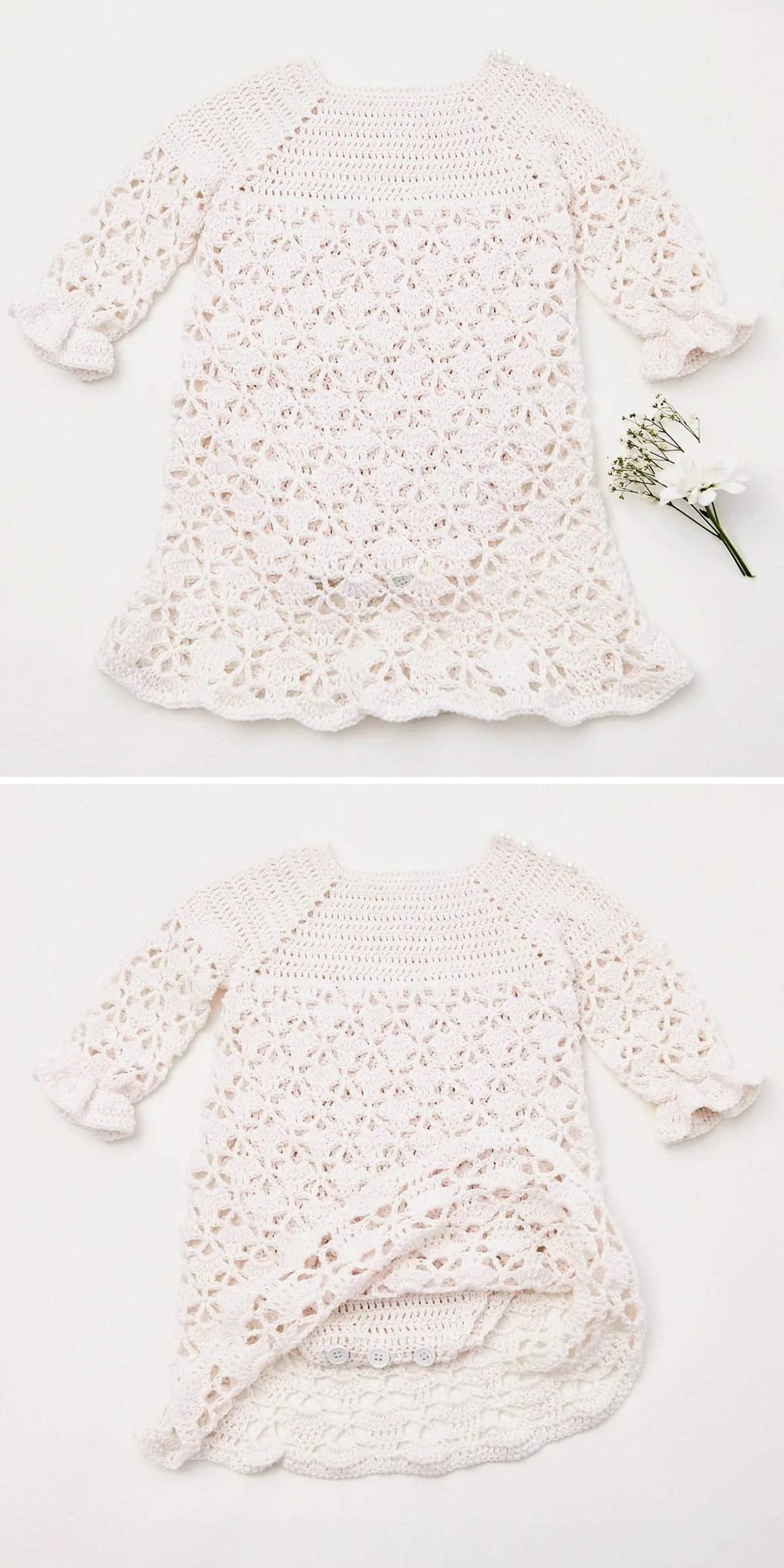 A cream-colored, crocheted baby dress with a lacy pattern and scalloped edges, displayed flat with a small sprig of white flowers beside it — perfect inspiration for your christening baby dress free crochet pattern project.