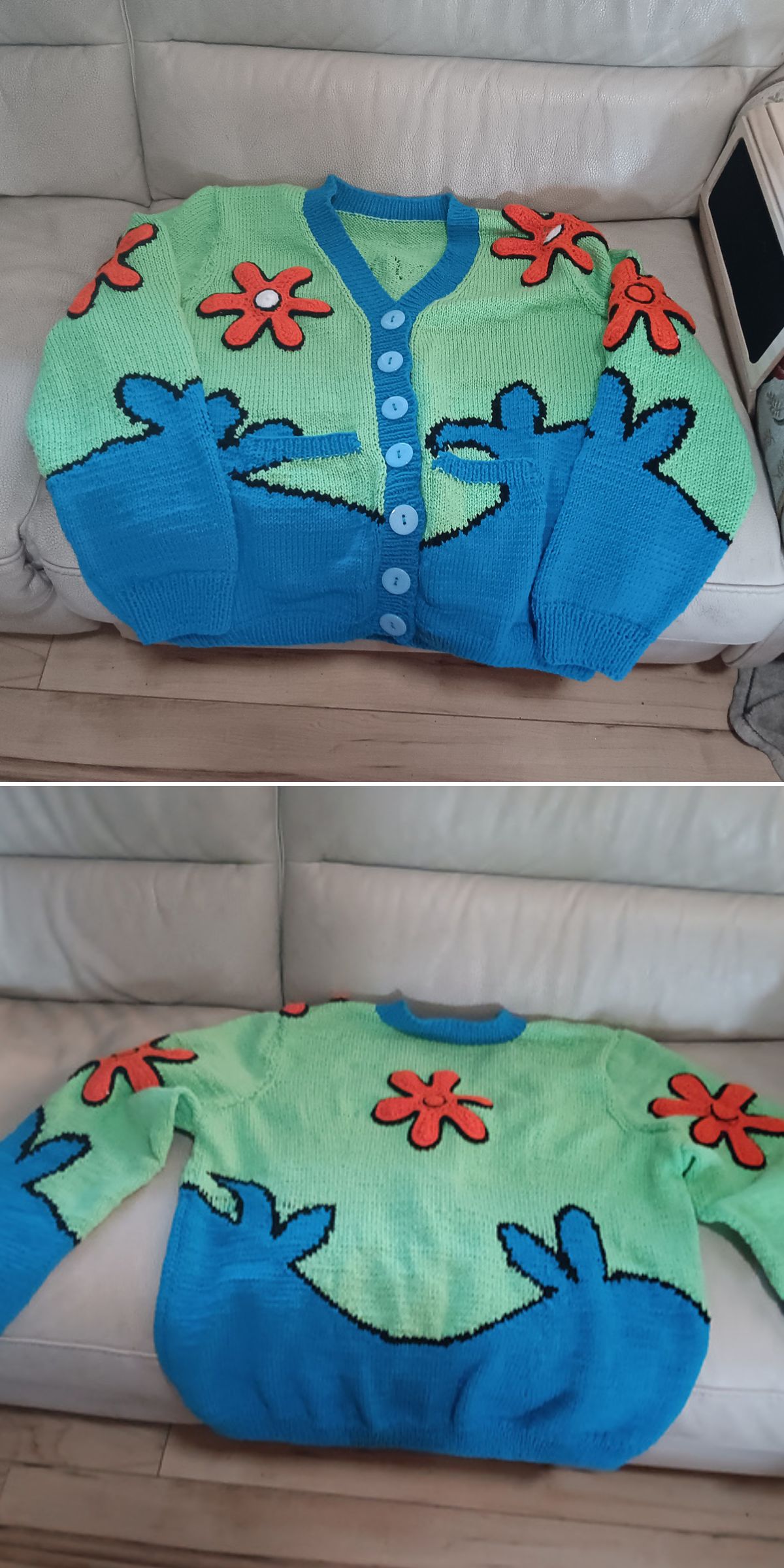A knitted cardigan with a blue lower half, light green upper half, blue buttons, and red-orange flower patterns on the front and back — perfect inspiration for those seeking Free Knitting Patterns for Cardigans. Displayed on a light-colored couch.