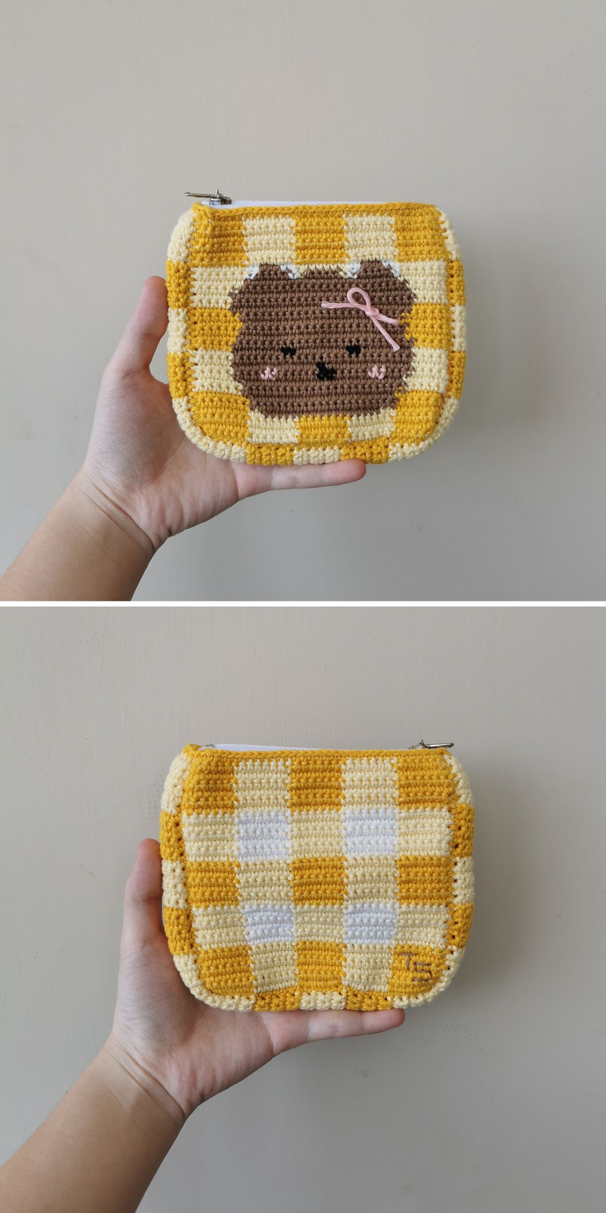 A hand holds a yellow and white checkered crochet bag for kids; one side features a bear face with a pink bow, while the other displays only the playful checkered pattern.