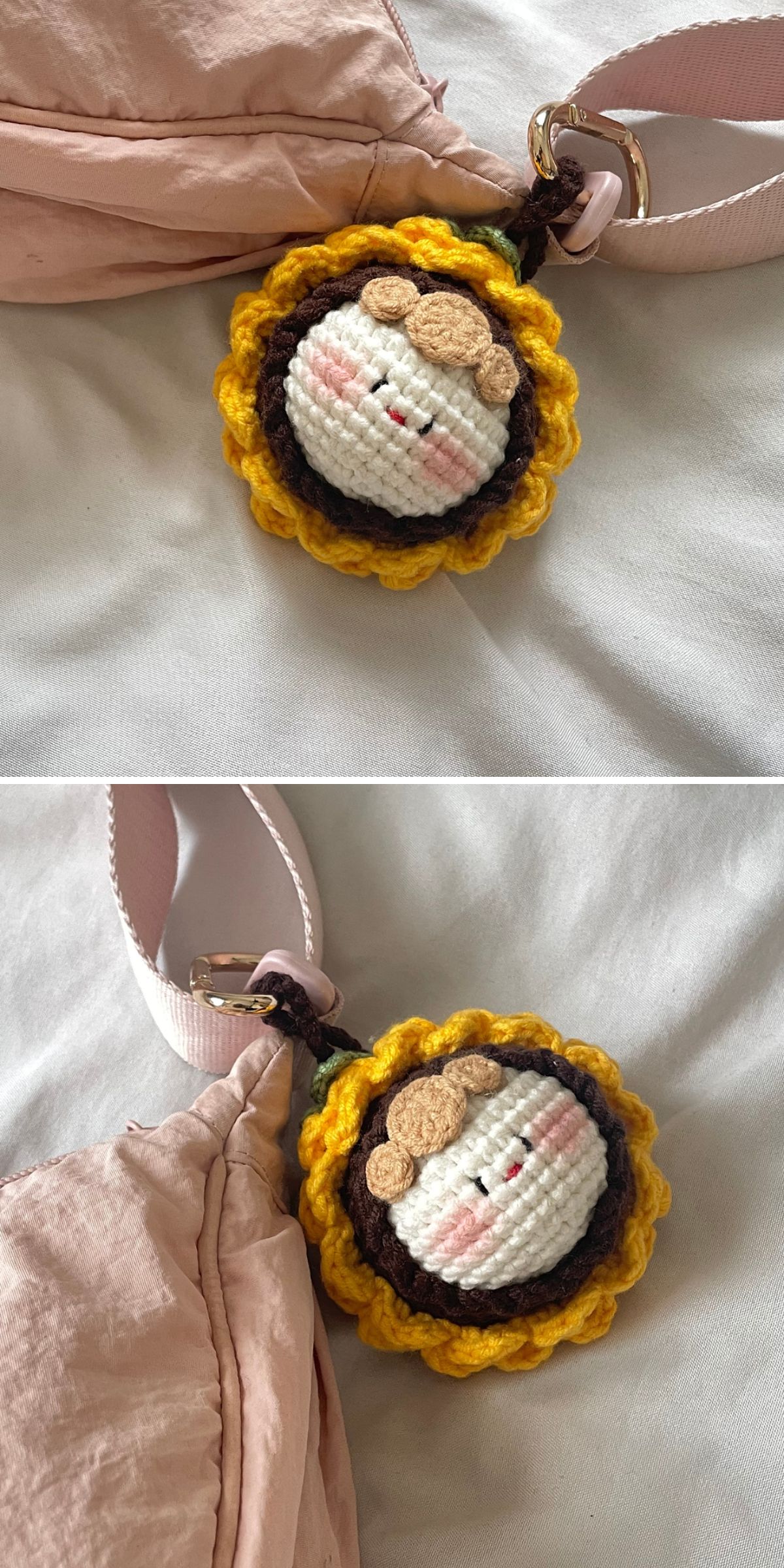 A crocheted keychain with a cartoon face and yellow petals, inspired by sunflower crochet, is attached to a light pink fabric strap and lying on a white surface.