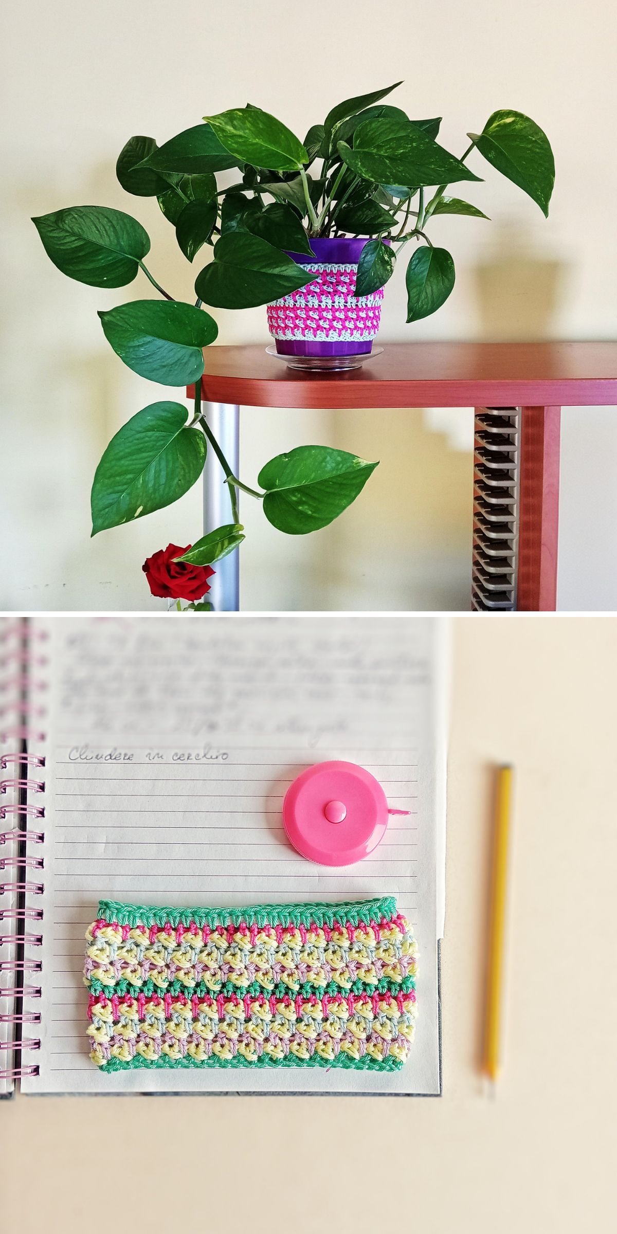 A green potted plant with a crochet plant pot cover sits on a shelf, while a notebook with handwritten notes, a pencil, a pink tape measure, and a colorful crocheted pot cozy displayed in flat rest on the desk.