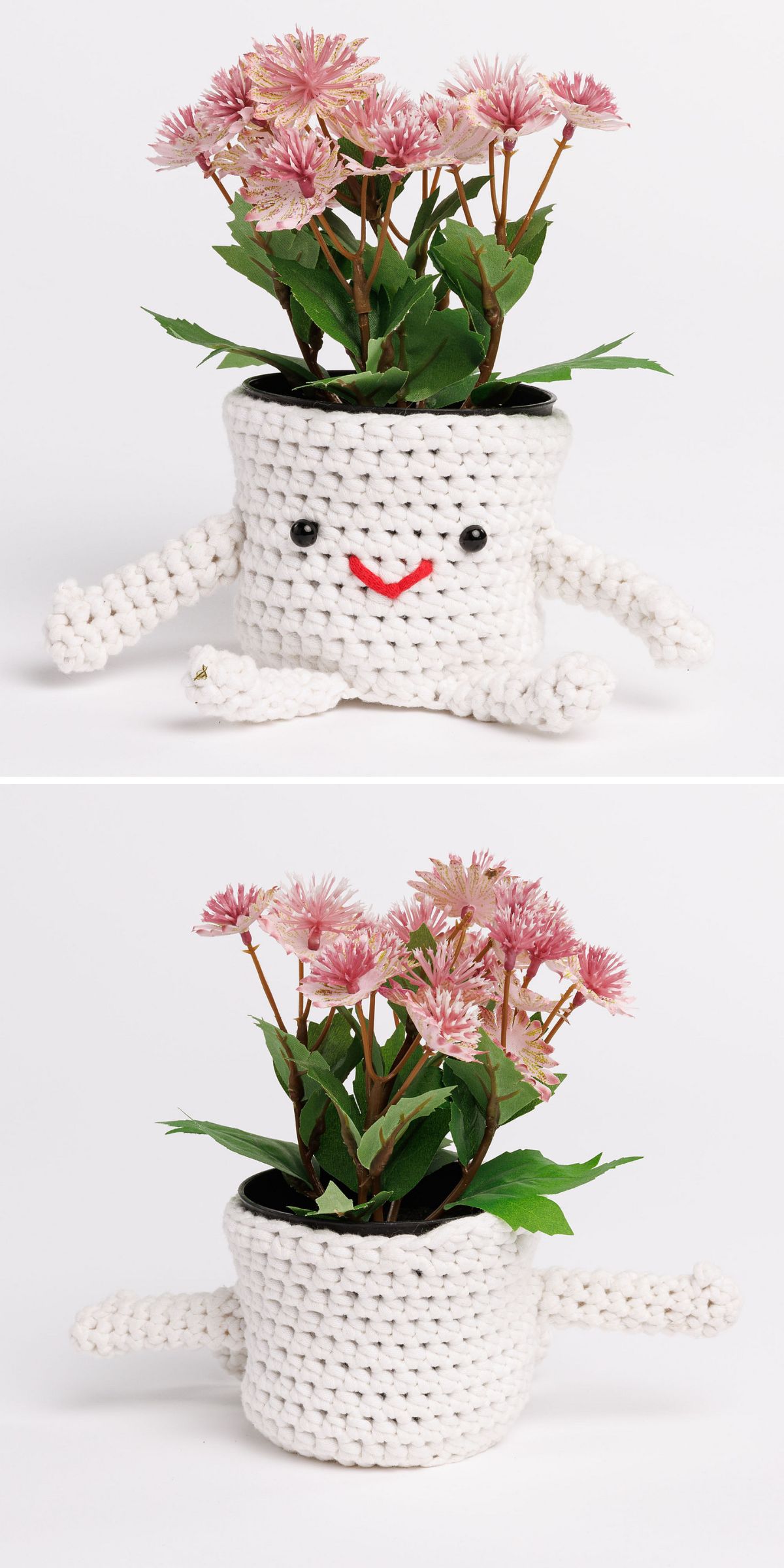 A white crochet plant pot cover with arms, legs, and a smiling face holds pink artificial flowers against a plain white background.