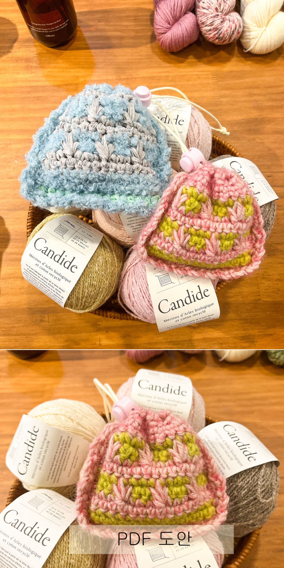 Two crocheted tiny pouches, one blue and one pink with green, are displayed on top of balls of Candide brand yarn alongside a matching crochet pouch on a wooden surface.
