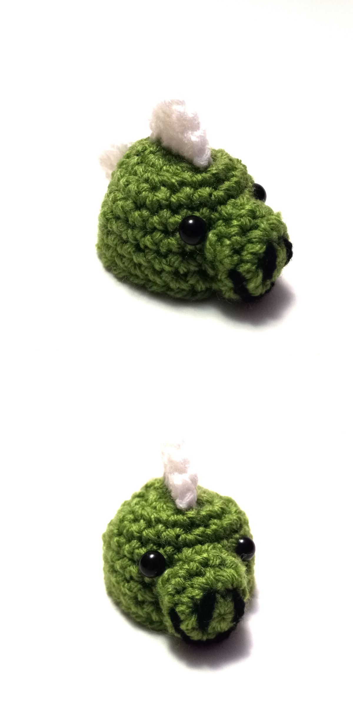 Two views of a small crochet dinosaur head hat show black eyes, a black nose and mouth, and a white horn on top.