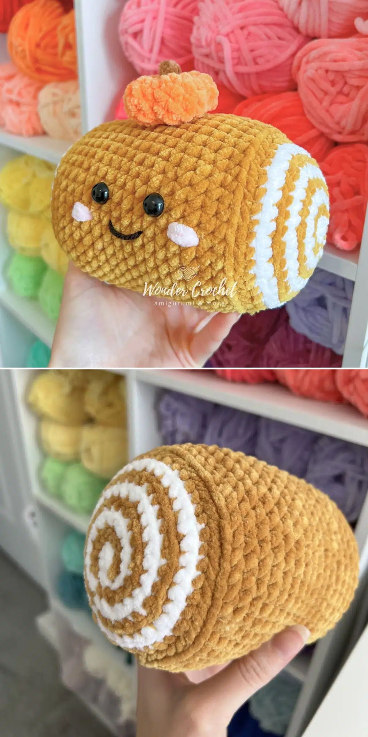 A hand holds a food amigurumi plush roll cake with a smiling face, decorative swirl, and small orange topping; yarn shelves are visible in the background.