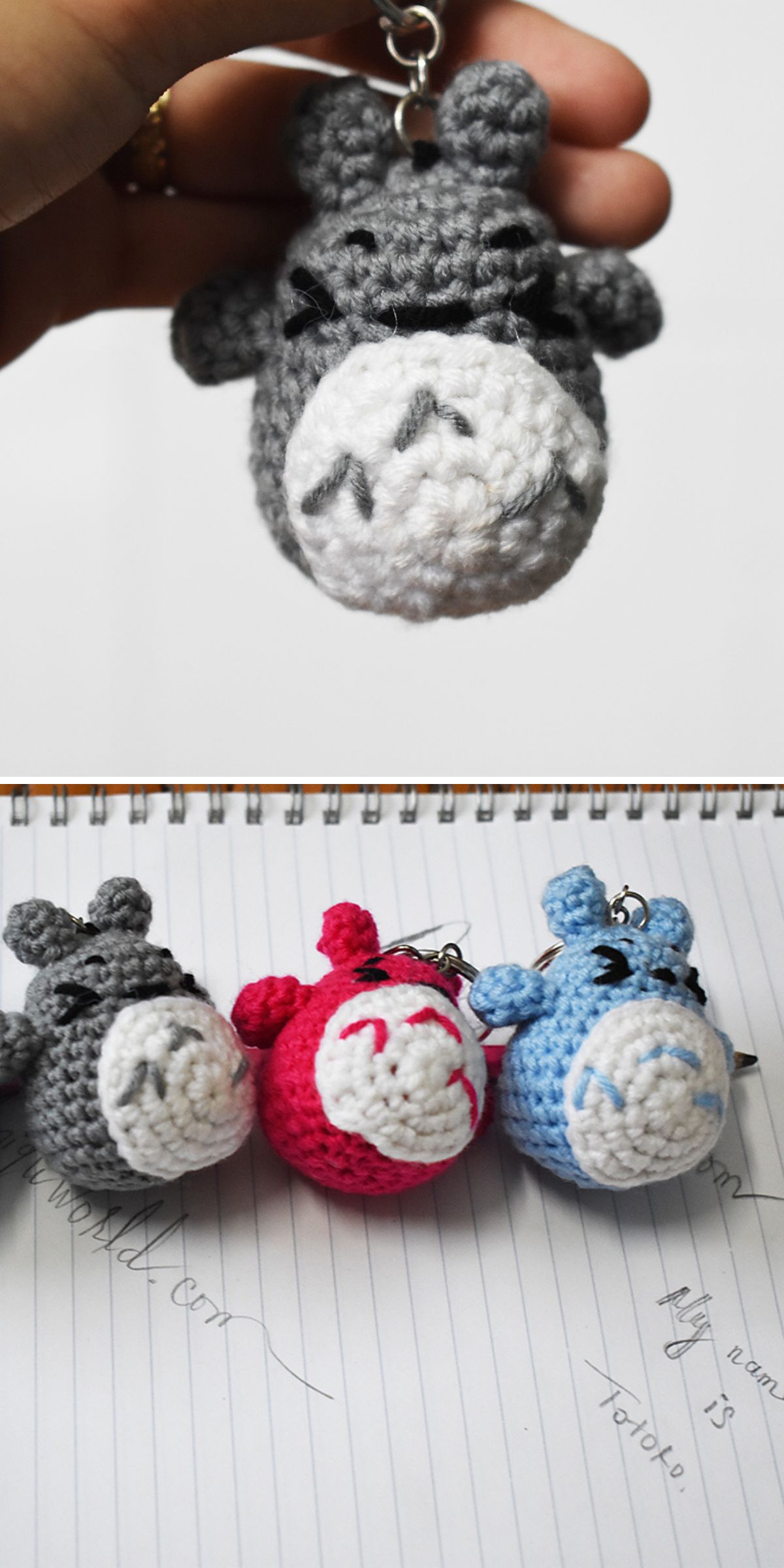 A hand holds a gray crochet Totoro keychain with a face. Below, three similar crocheted animal keychains in gray, red, and blue rest on a notebook with handwritten notes.