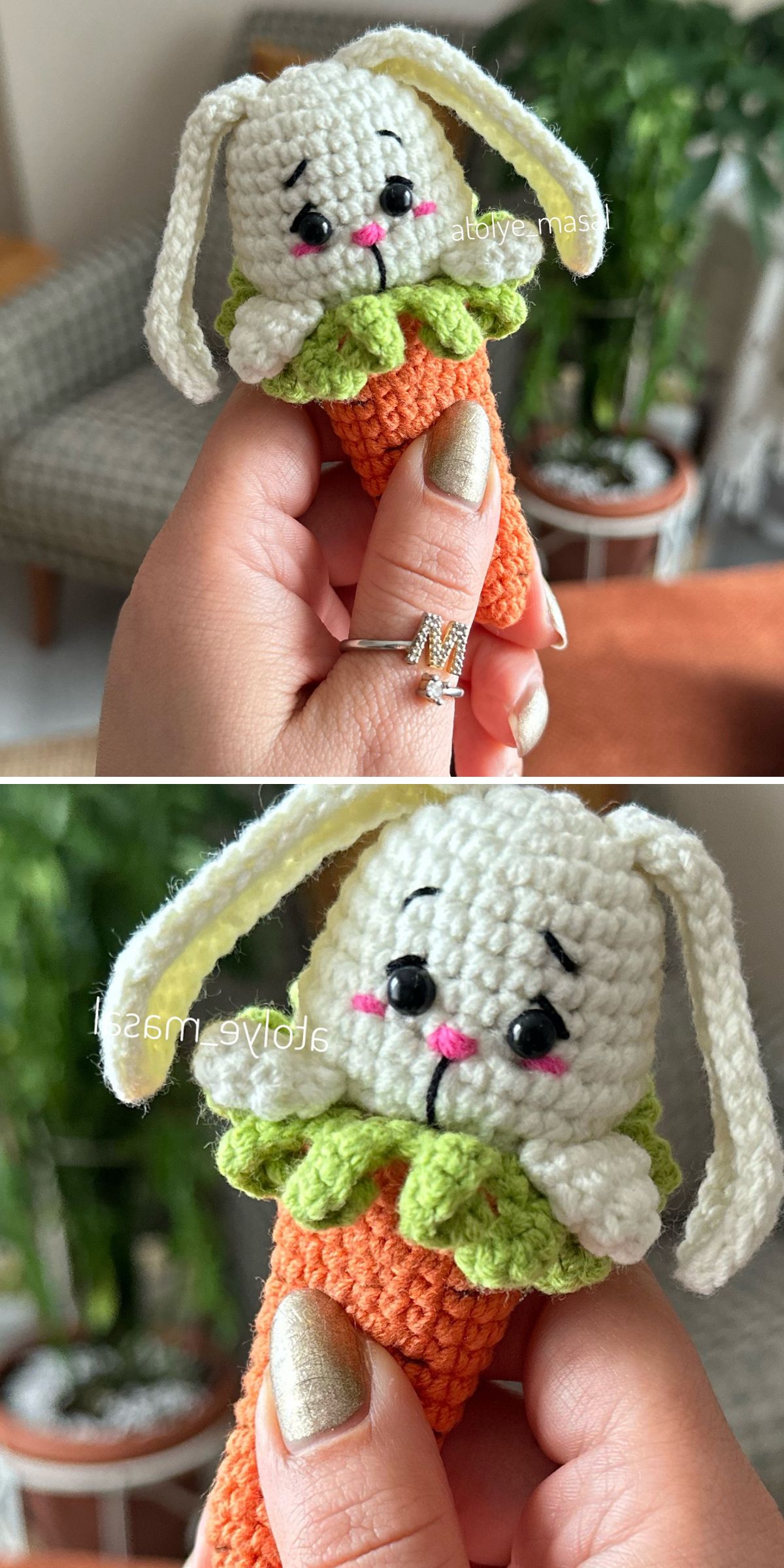 Hand holding a crochet bunny with floppy ears and a sad expression, attached to an orange carrot; indoor setting with plants in the background.