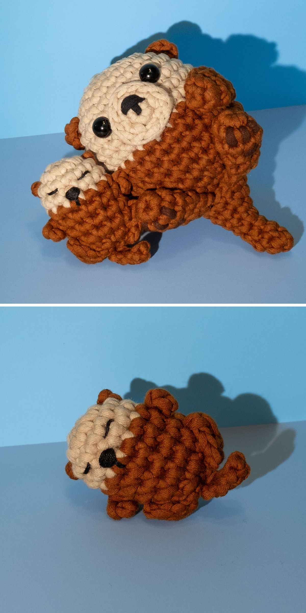 Tiny crochet sea otter amigurumi in brown and cream yarn, posed cuddling a smaller sleeping baby otter against a blue background.