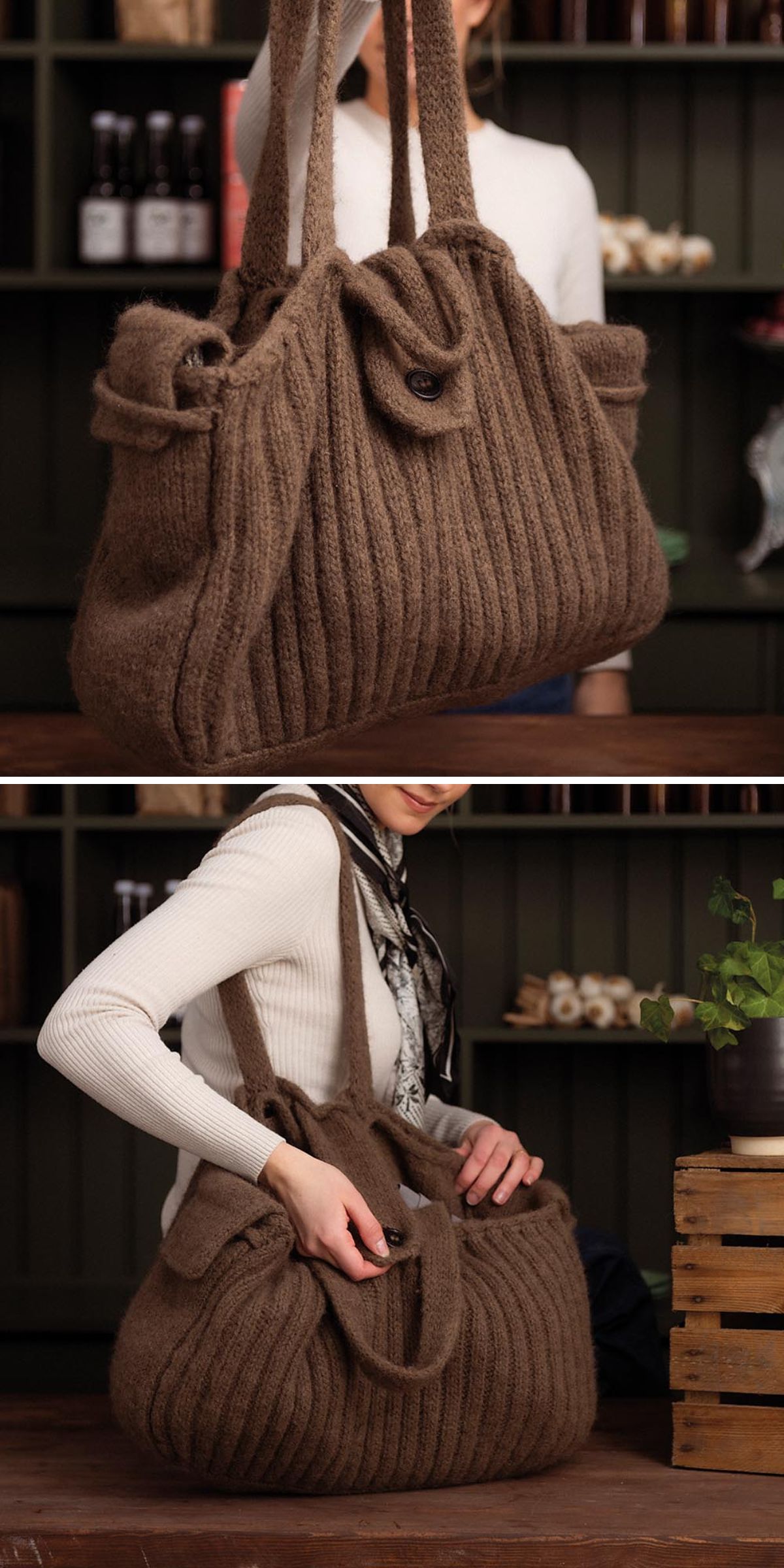 A person wearing a white sweater holds and opens a large, brown, knit bag with buttons, displayed indoors on a wooden surface.