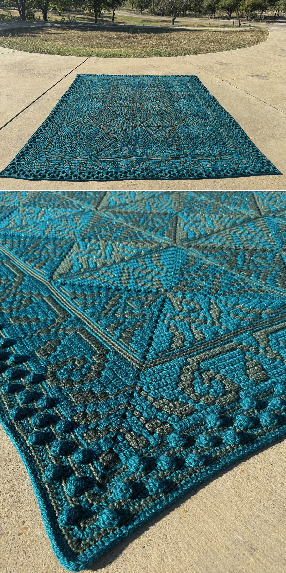 A large, rectangular bobble stitch blanket featuring a blue and dark teal geometric pattern is laid out on a concrete driveway with grass and trees in the background.