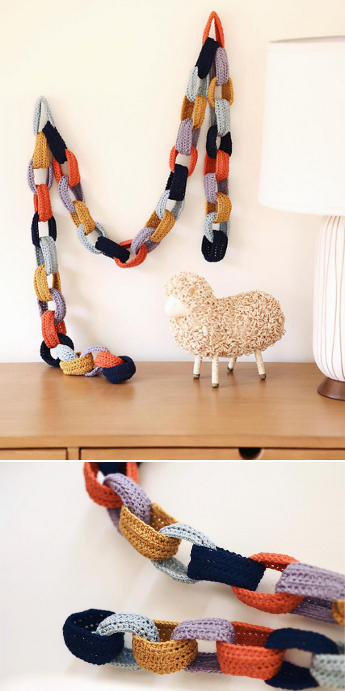 A multicolored crochet chain garland, inspired by Crochet Wall Hanging Patterns, is draped on a wall above a wooden table with a decorative sheep figure and a white lamp — perfect for adding charm to your home decor.