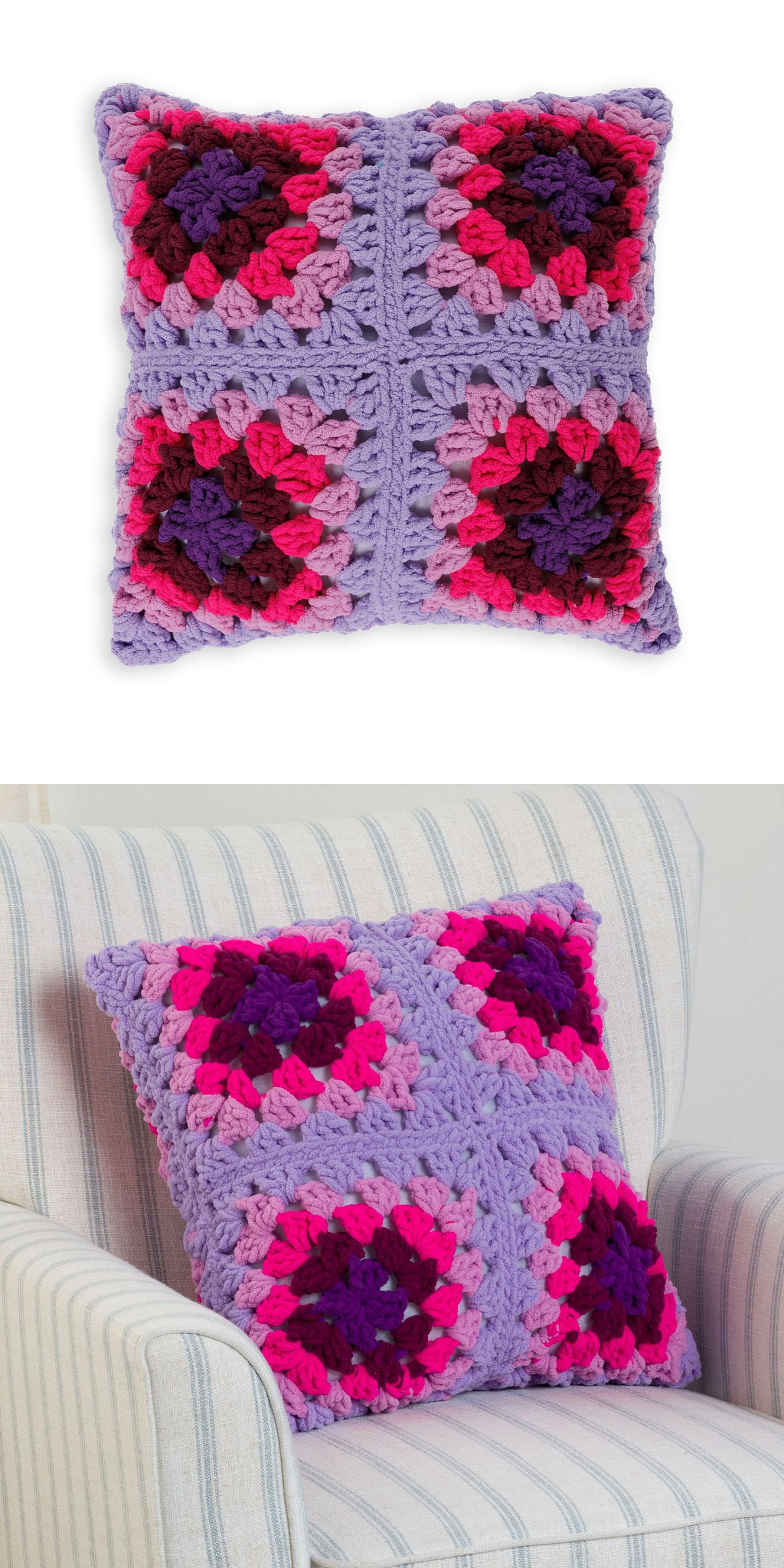 A crochet pillow featuring a purple, pink, and red granny square pattern is shown on a white background and placed on a striped armchair.