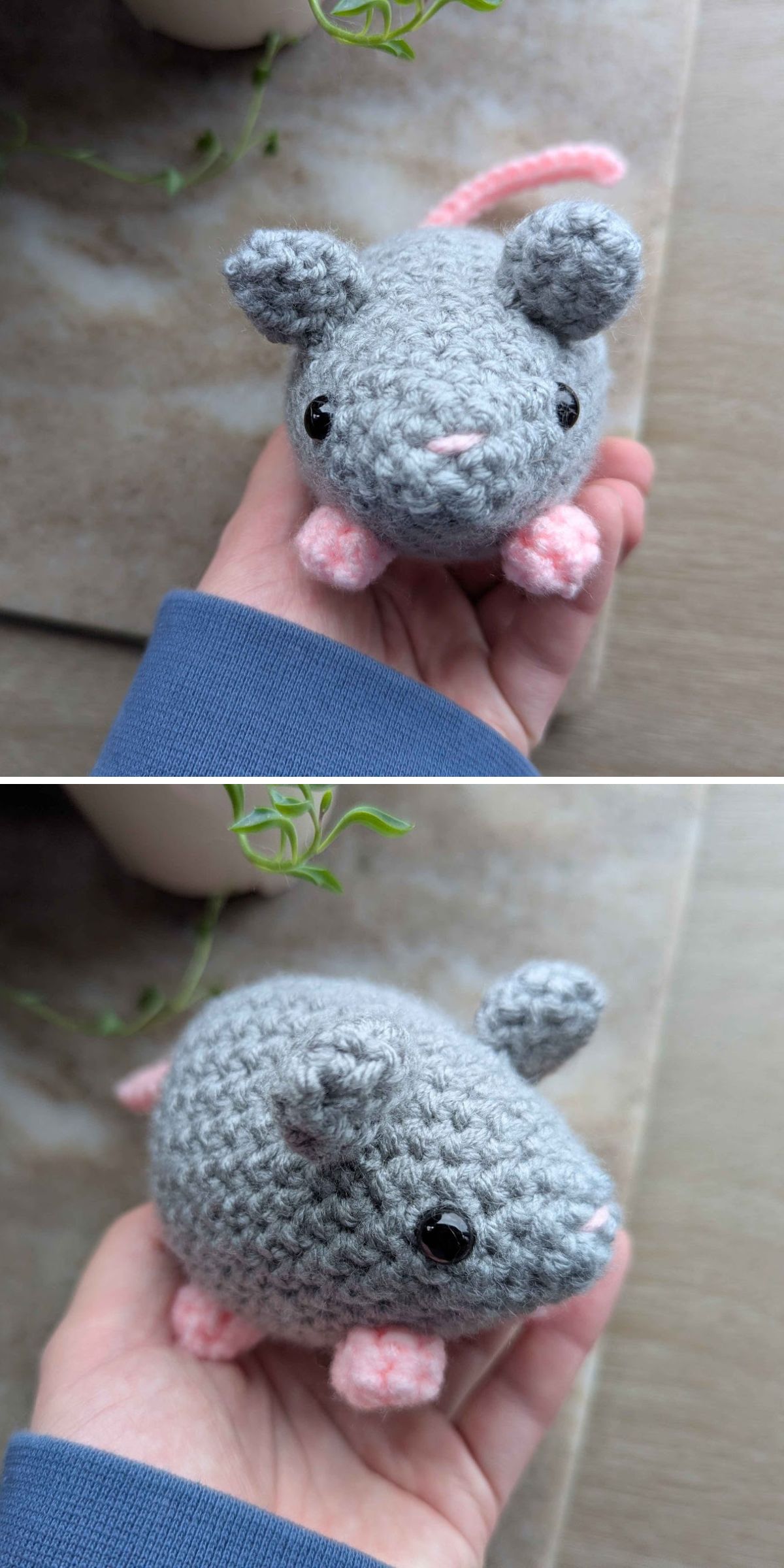 A hand holds a small, crocheted gray rat with pink feet, nose, and tail. This adorable crochet animal features black bead eyes and is displayed on a neutral surface.
