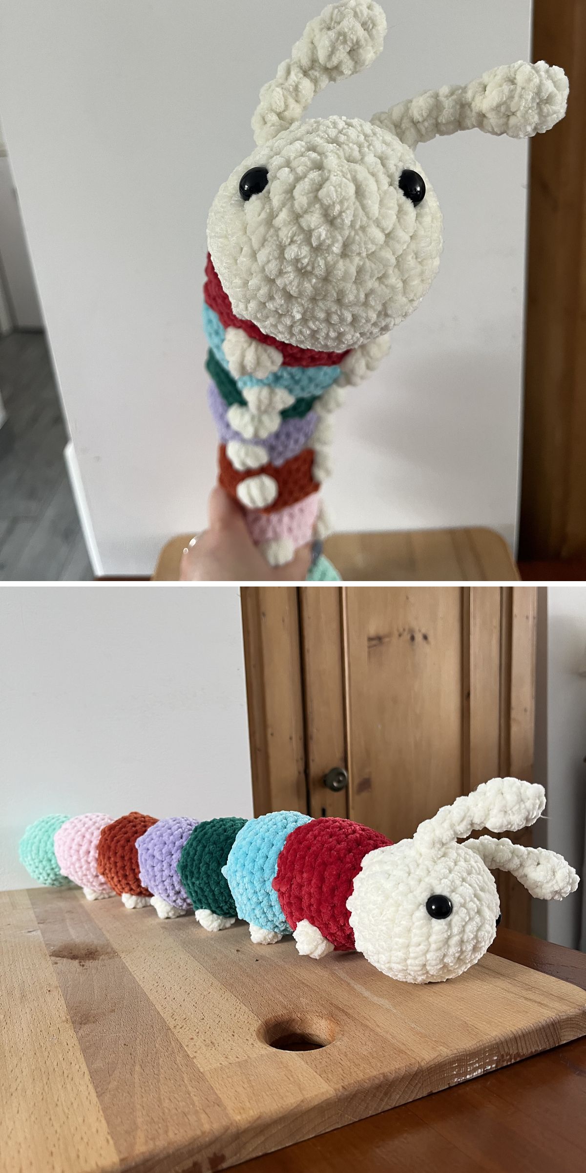 A plush crochet insect toy - a caterpillar - with a white head, black eyes, and a multicolored body is shown on a wooden surface and held in a hand.