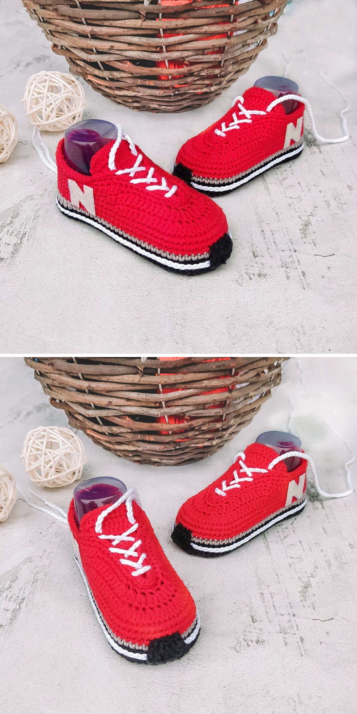 Two red and white crocheted sneakers with laces and an “N” on the side, designed to resemble playful crochet slippers, are placed on a light surface near a wicker basket and decorative balls of twine.