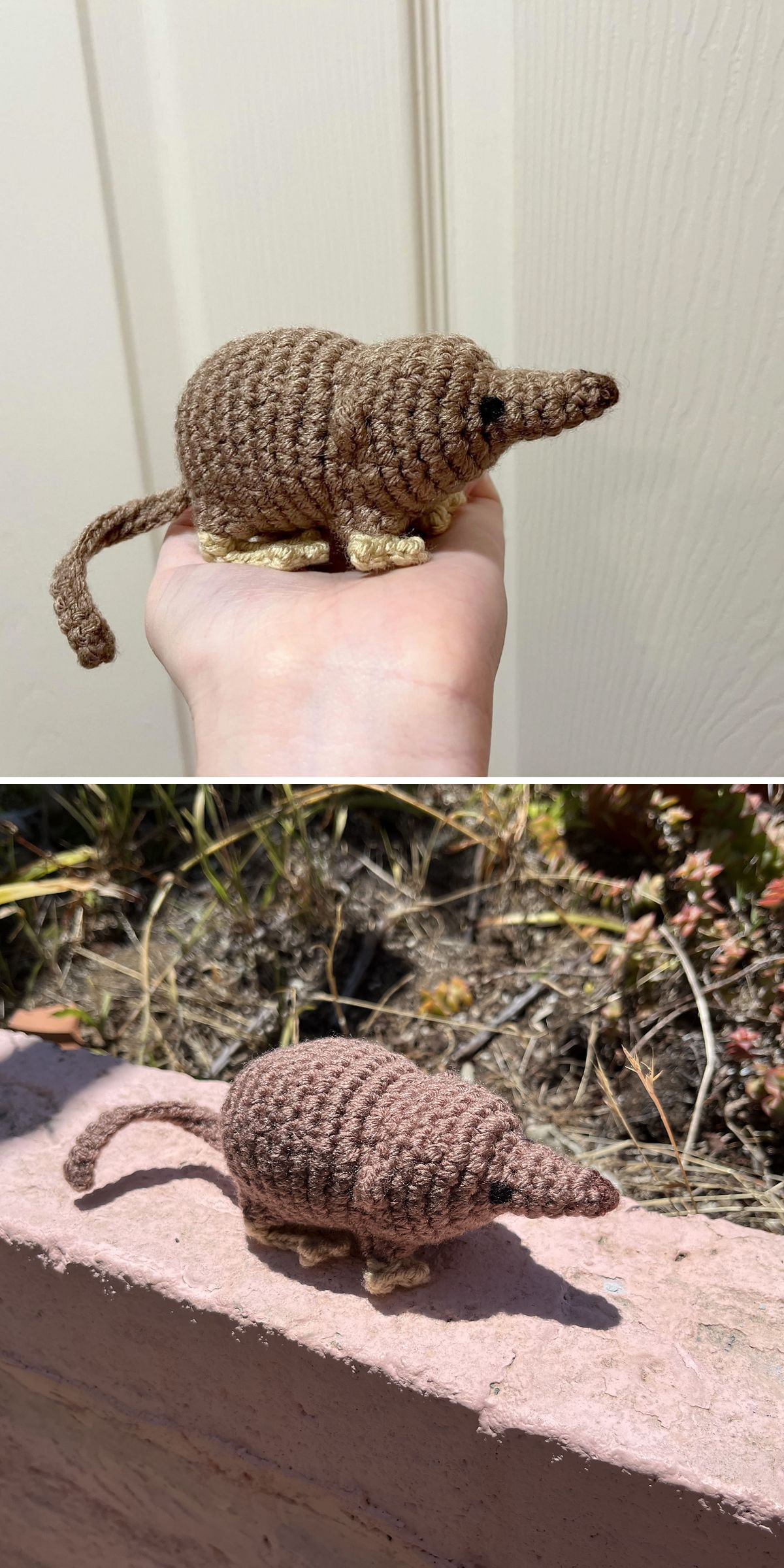 A small, crochet animal shrew with a long tail and pointed nose is shown in a person’s hand and resting on a garden ledge outdoors.