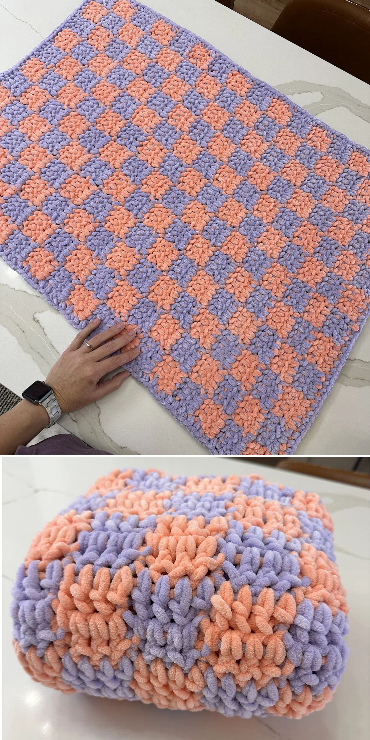 A crochet chunky blanket, hand-crocheted with a checkerboard pattern in peach and lavender yarn, is displayed flat and folded on a light-colored surface.