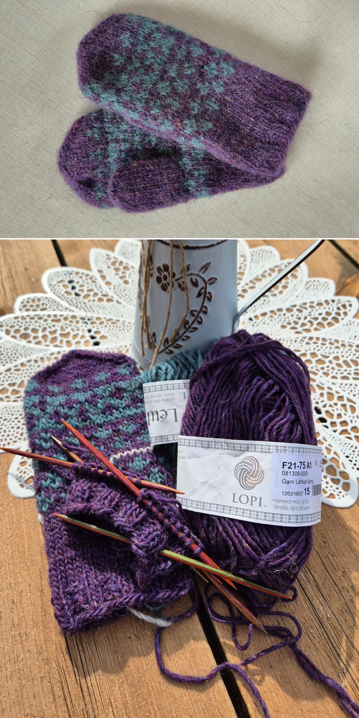 Two purple and teal knitted mittens — one finished and one knitted mitten in progress with yarn, knitting needles, and a yarn label—are displayed on a lace doily atop a wooden surface.