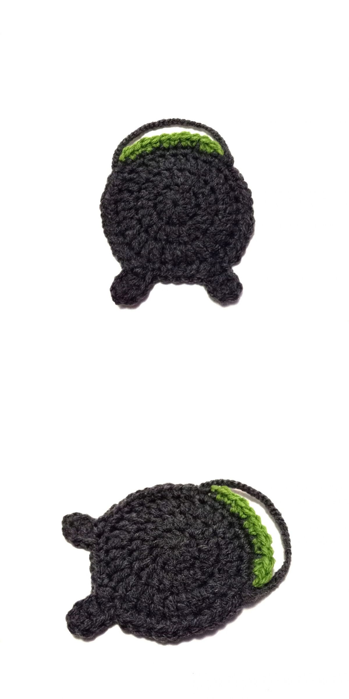 Two crocheted black cauldrons with green interiors are shown on a white background, one upright and one lying on its side — the perfect addition to your next crochet Halloween coaster.