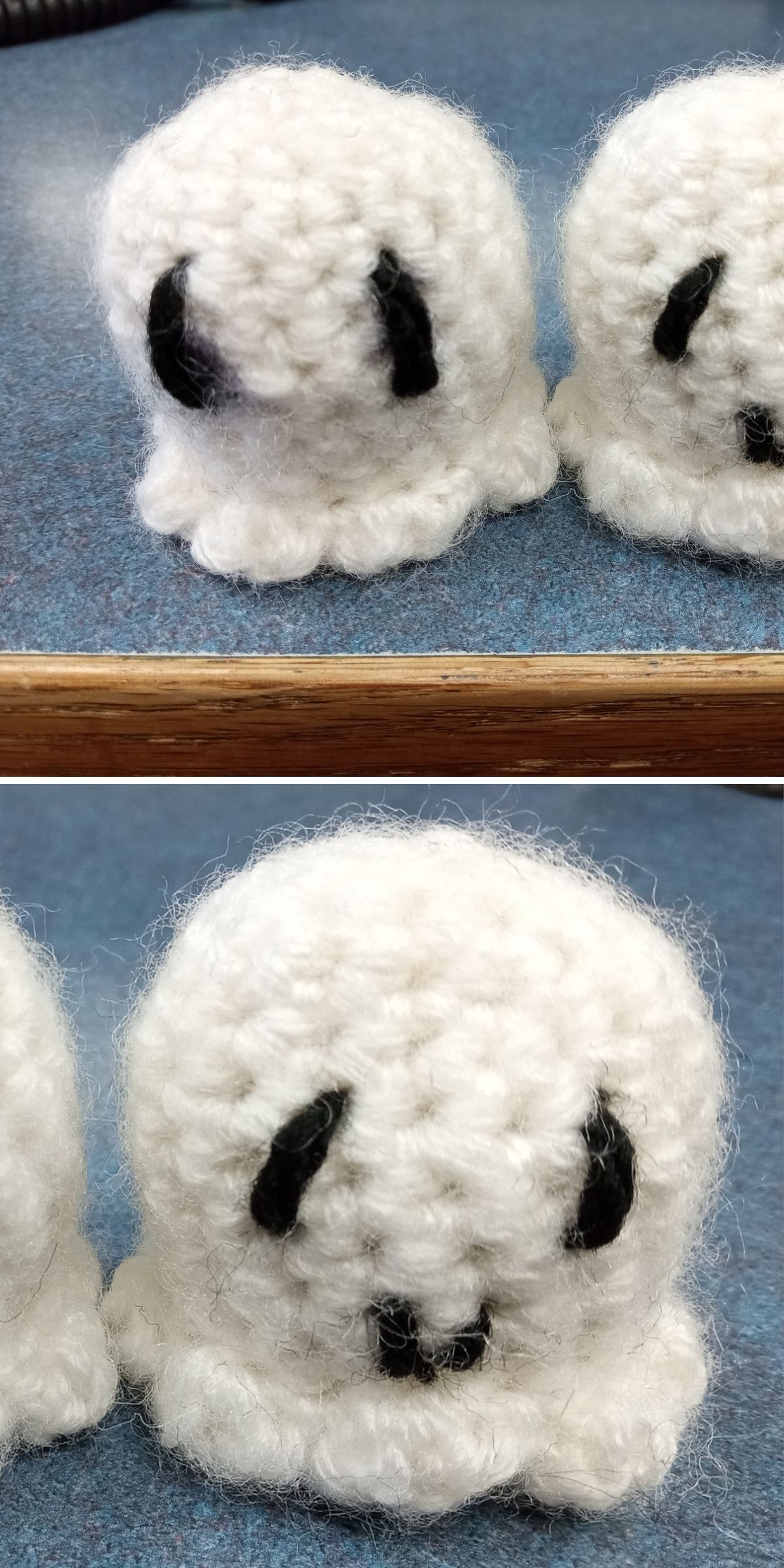 Two small crocheted white ghost figures with black stitched eyes and mouths, shown on a blue tabletop—perfect for Halloween decorations or using as inspiration for your own crochet ghost patterns.